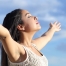 peaceful woman taking deep breath with blue sky background showing how to get over sorrow.