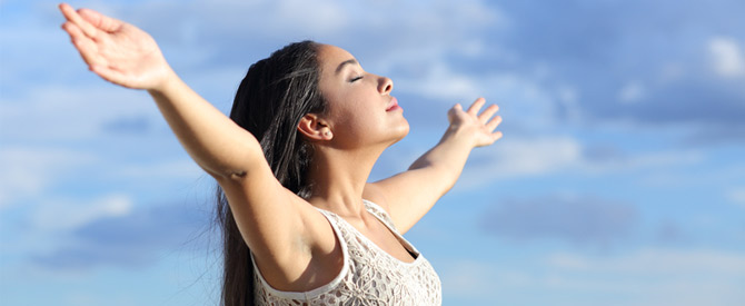 peaceful woman taking deep breath with blue sky background showing how to get over sorrow.