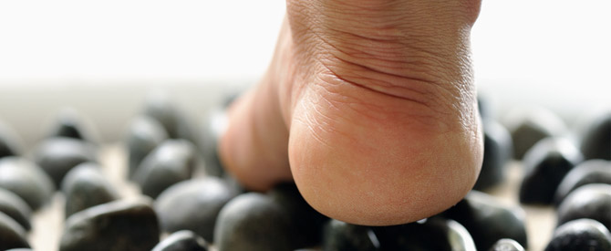 walking on foot reflexology stones