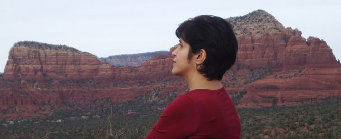 woman sitting in reflection amidst mountains in Sedona