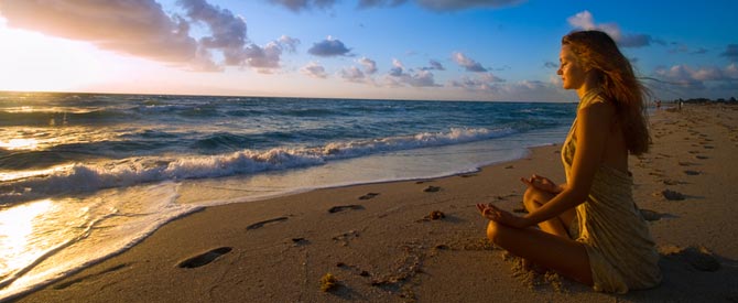 Peaceful woman meditating on the beach