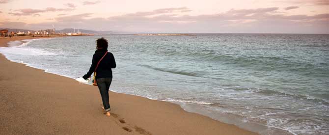 woman walking on the beach at sunset