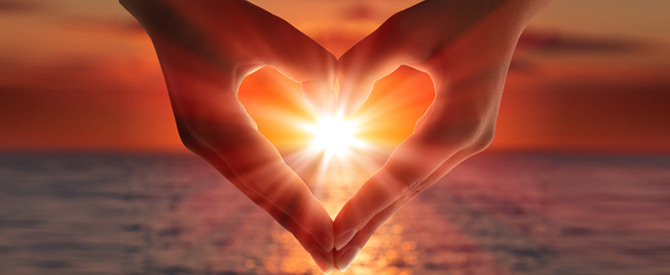 hands in a heart shape with sun inside