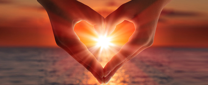 hands in a heart shape with sun inside