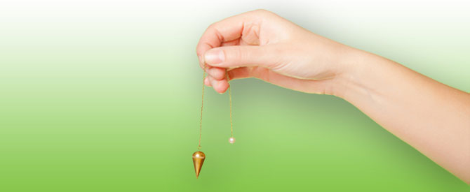 Hand holding a pendulum.