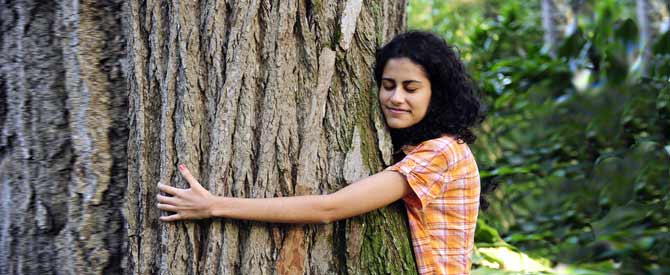 Woman happily hugging a tree