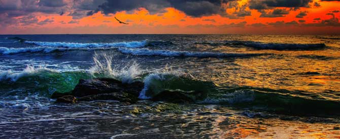 rough ocean waves on a backdrop of an orange sky.