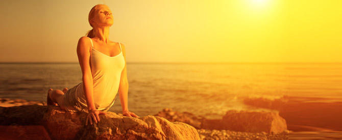 woman in yoga cobra pose on the beach