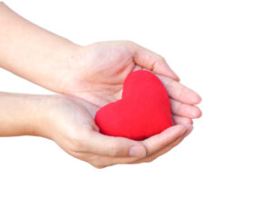 hands offering a heart symbolizing offering actions to the divine which will bring freedom from the cycle of birth and death