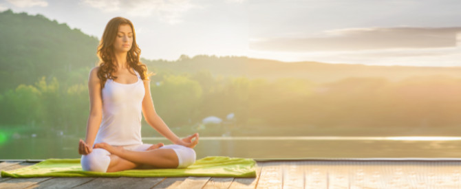 woman in meditation by the lake