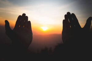 Silhouette of hands invoking divine grace.