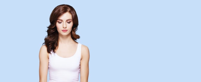 woman in white meditating on blue background