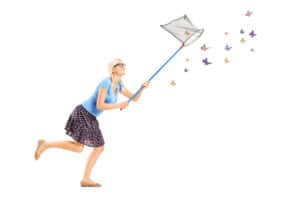 woman chasing butterflies with a net looking for happiness and a peaceful mind