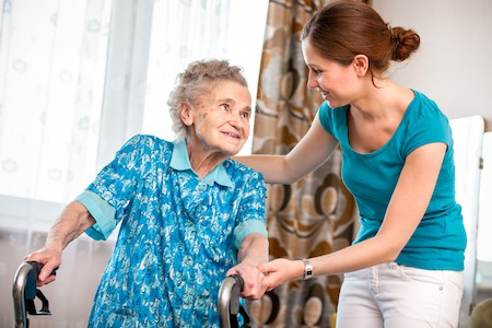 Humility and service being practiced by a caregiver to a senior in her home