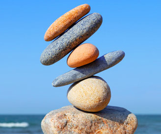 Unstable stack of rocks symbolizing negative emotions that arise from not tuning in to God inside you