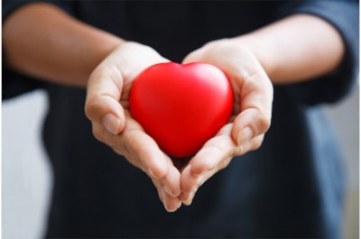 red heart held by woman's hands representing offering forgiveness, a quality to cultivate your heart