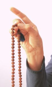 hand showing how to hold a mala for japa practice