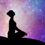 Woman silhouette in yoga lotus pose looking up to the stars as though asking God to fulfill your desires.