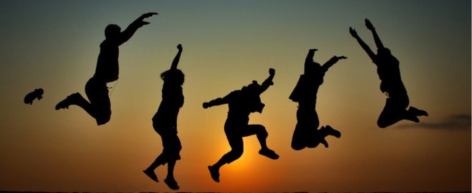 Silhouette of happy jumping youth with sunset behind showing spirituality for young people