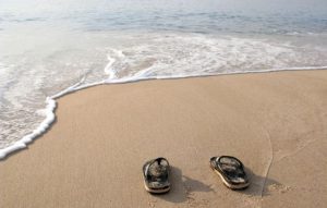 Pair of slippers on the seashore