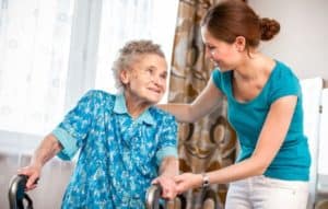 Compassionate young woman helping an elderly woman walk.
