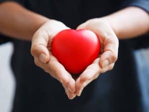 Hands holding a red heart as gesture of love